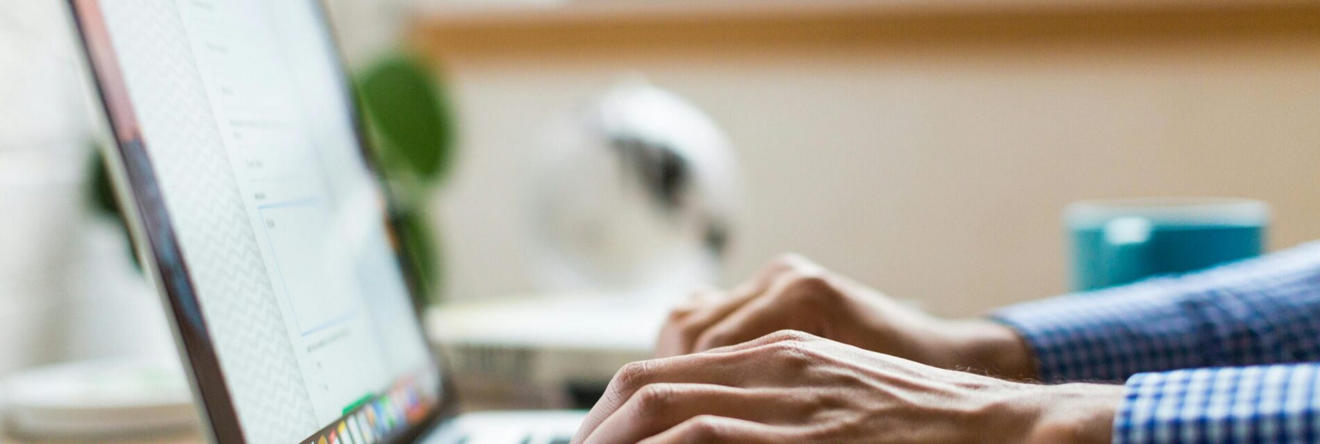 Vue de profil d'un ordinateur avec deux mains en train d'écrire sur le clavier