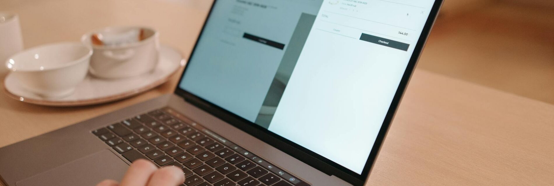 Main utilisant le trackpad d'un ordinateur affichant une interface