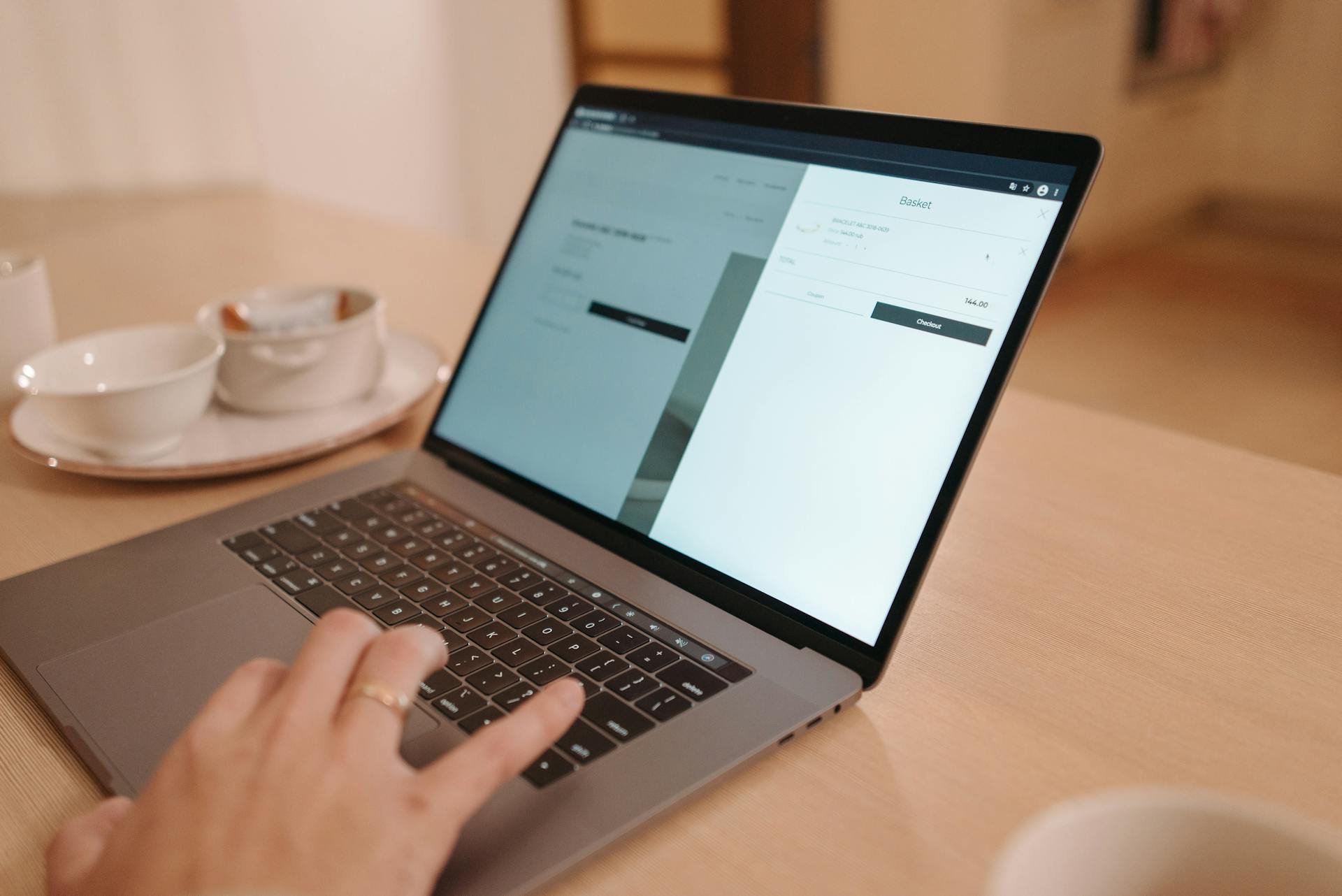 Main utilisant le trackpad d'un ordinateur affichant une interface