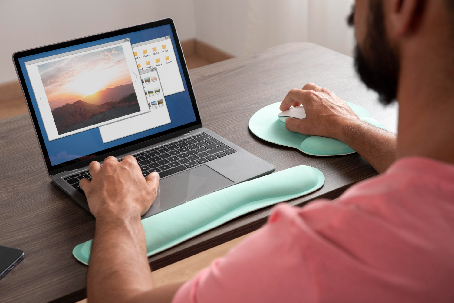 Homme travaillant à un ordinateur et visionnant une image, une main sur le clavier, l'autre sur sa souris