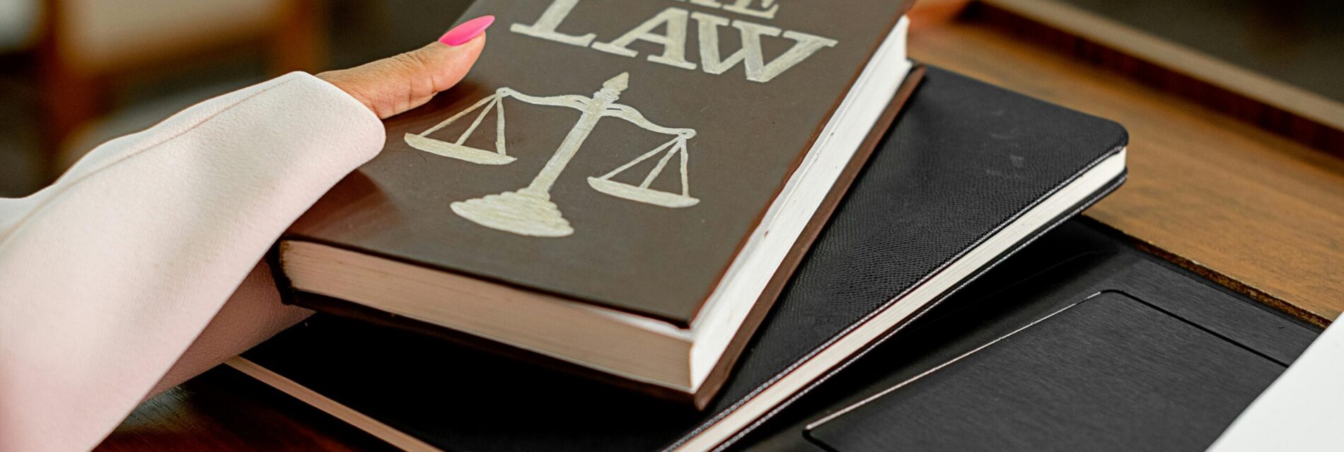 Main prenant un livre sur lequel est écrit The Law