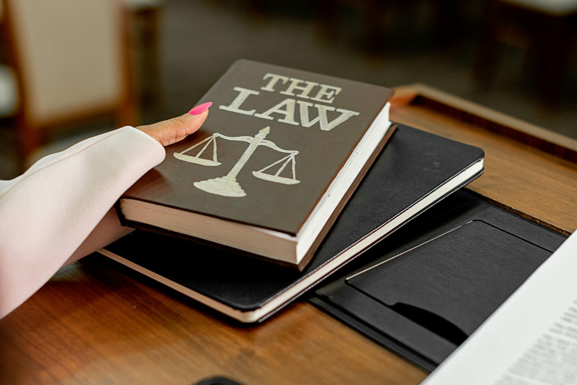 Main prenant un livre sur lequel est écrit The Law