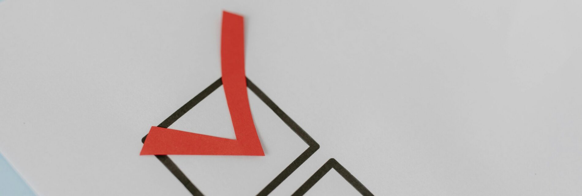 Case en bordure noir coché d'un V en rouge sur feuille blanche